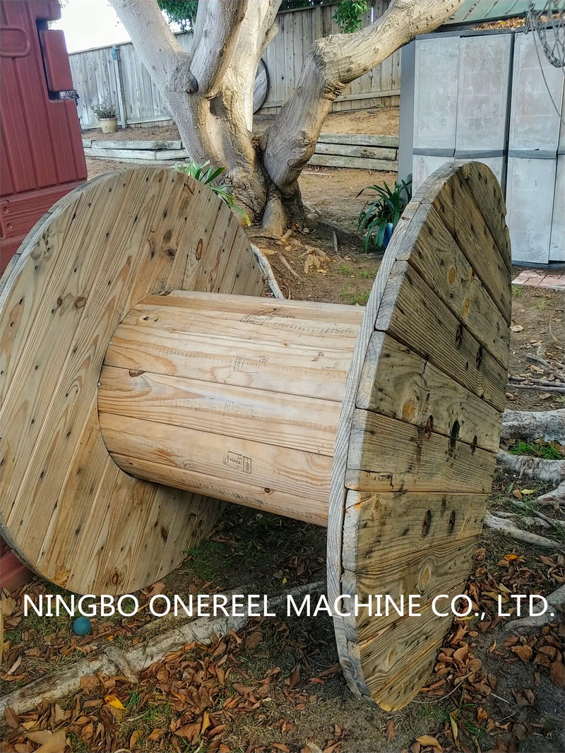 A large old empty wooden cable spool on grass Stock Photo - Alamy