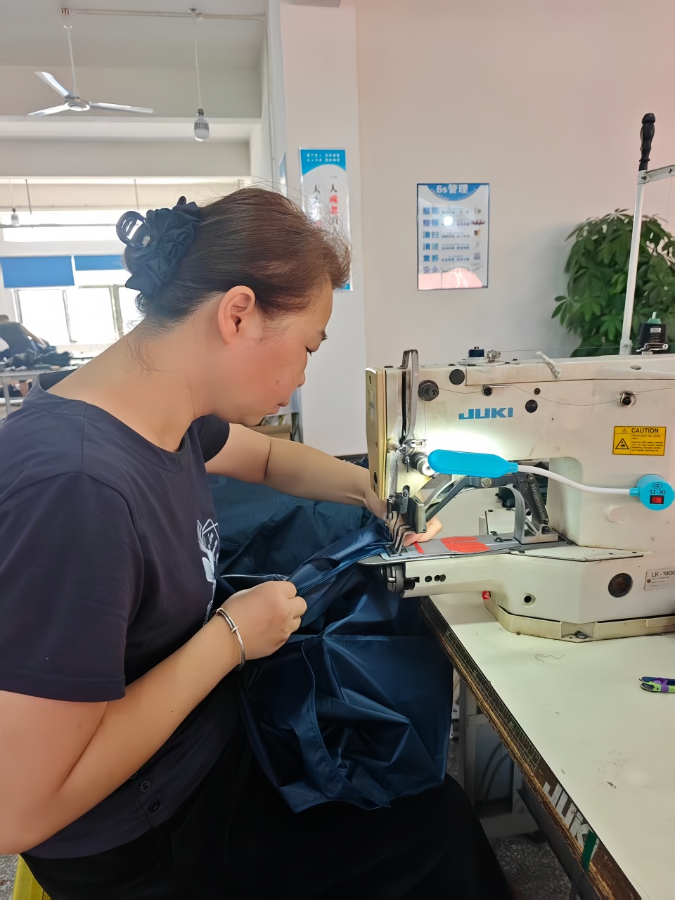 Worker-sewing-umbrella-top-and-strap-on-special-machine
