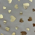 Tessuto in tulle di poliestere con stampa laminata di cuori dorati