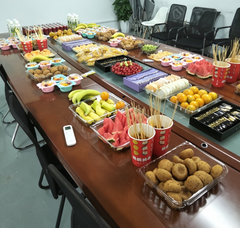 Baisite team enjoying afternoon tea with fruits and snacks at office