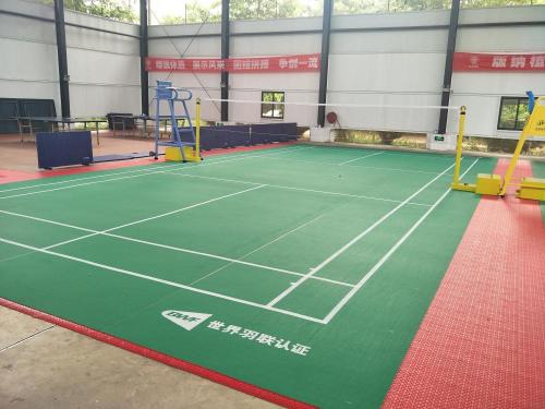 Competencia de bádminton utilizando un piso PVC de patrón de arena subyacente