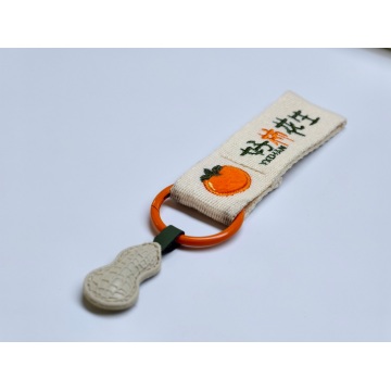 Petit pendentif logo brodé en ruban tissé