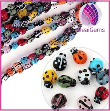 Bead, lampworked glass, multicolored, 7x9mm ladybug with eyes.