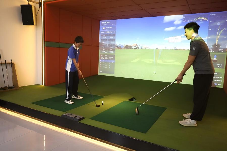 Children receiving guided golf simulator training during a factory visit