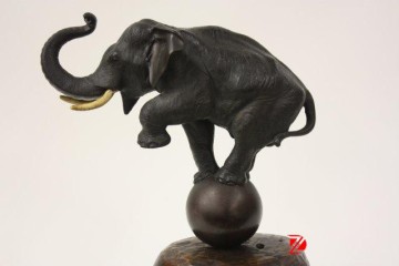 bronze elephant sculpture playing a ball