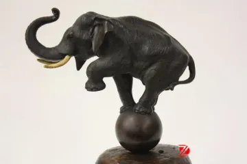 bronze elephant sculpture playing a ball