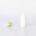 Opaque white essential oil glas bottle with golden dropper cap