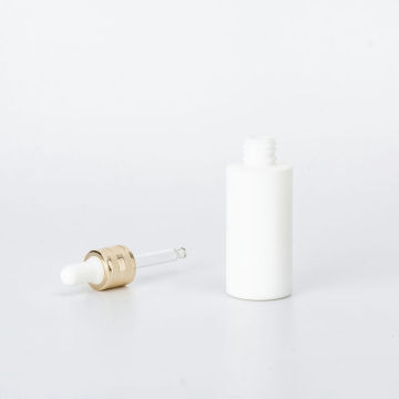 Opaque white essential oil glas bottle with golden dropper cap