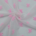 Beflockter Netzstoff aus 100 % Nylon mit rosa Schleife