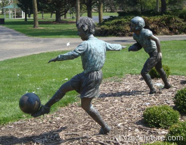 Ragazzo di bronzo che gioca scultura di calcio per la vendita