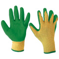 Желтые хлопковые рабочие перчатки, смоченные зеленым латексом