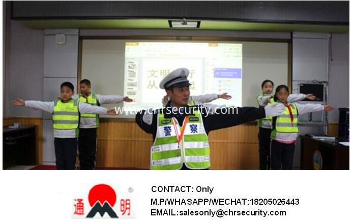 Primary school students wear reflective clothes as traffic police