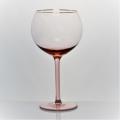 pink colored wine glass set with gold rim