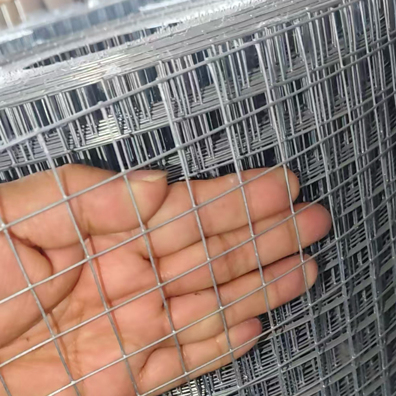 Hand against galvanized welded wire mesh roll showing opening scale -- manufactured by ANJIA 70,000sqm ISO facility