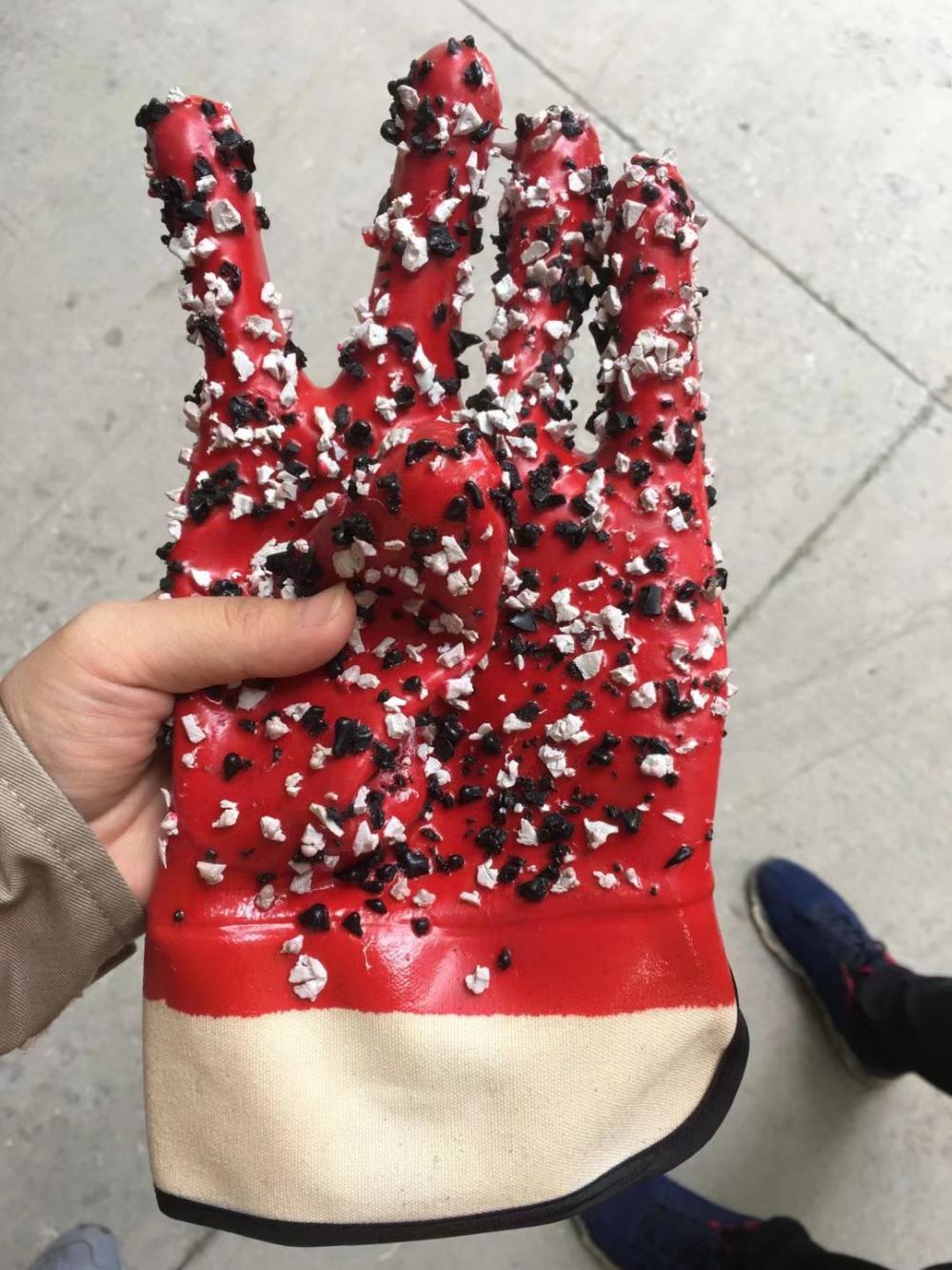 Red pvc gloves with chips on the palm