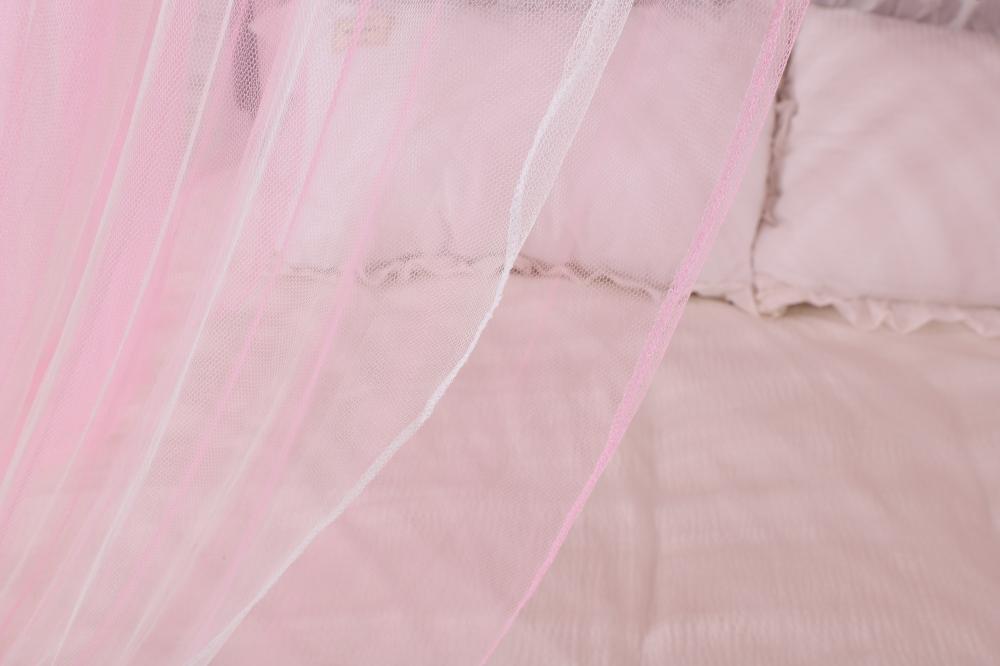 Pink bed canopy hanging from ceiling