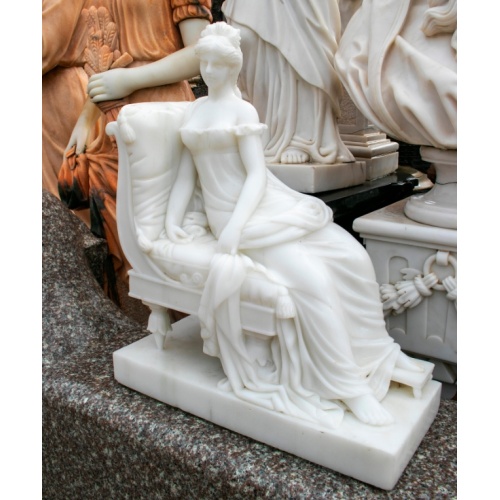 Elegante dama descansando sobre escultura de sofá de mármol