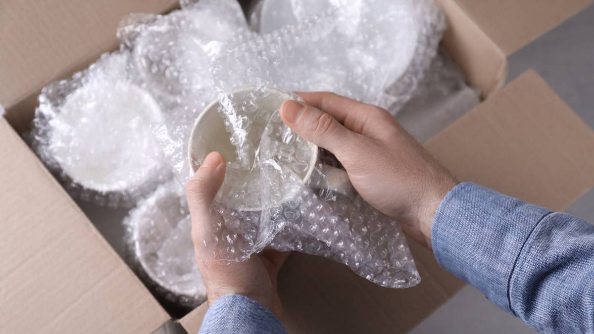 1678760376211-a-man-wrapping-dishware-with-bubble-wrap