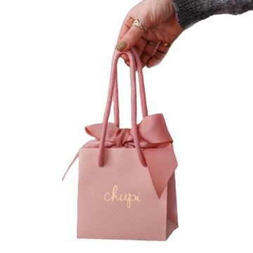 Petits sacs-cadeaux en papier rose avec cravate en ruban