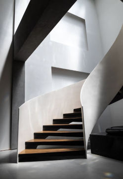 large curved rotating hollow solid wood staircase