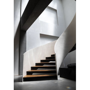 درج كبير من الخشب الصلب المجوف والدوار المنحني في ردهة الفندق