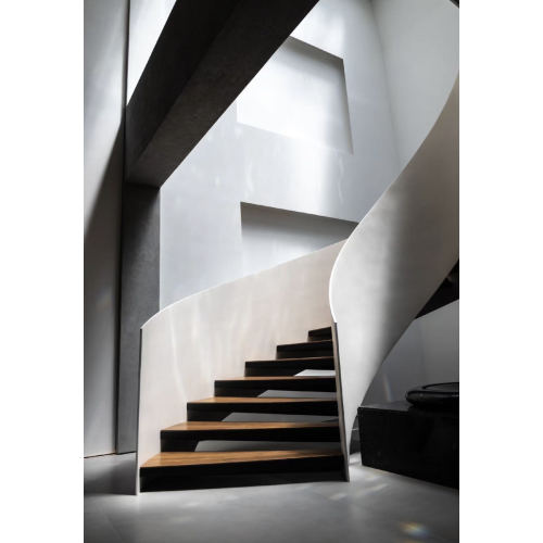 درج كبير من الخشب الصلب المجوف والدوار المنحني في ردهة الفندق