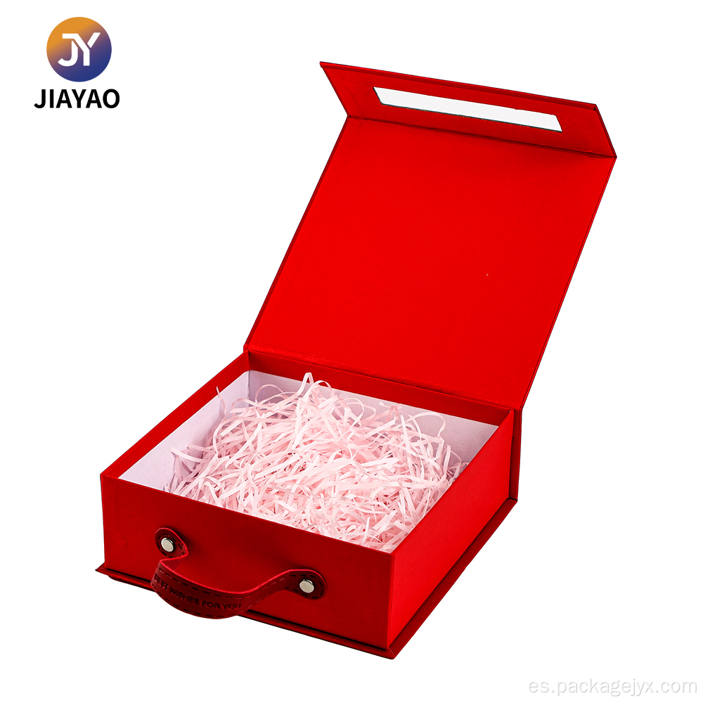 Elegante caja roja con asa de cuero y borla.