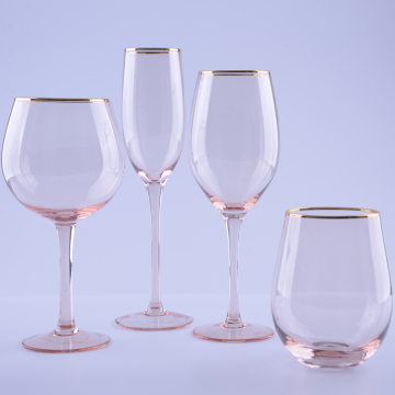 Rosa färgade rödvinsglas med guldkant