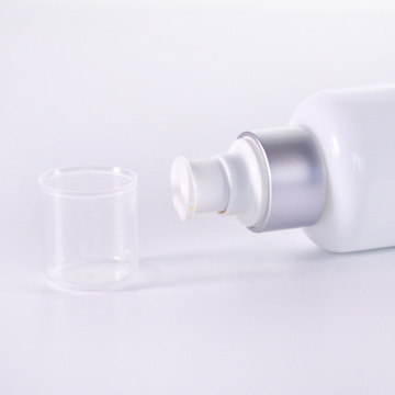 Botella de loción de vidrio blanco con bomba de plata
