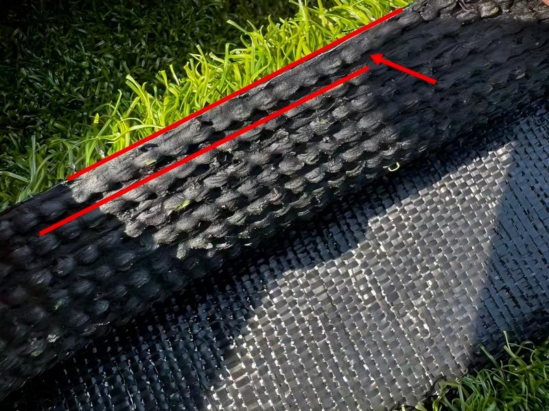 Trim the synthetic golf green turf edge along the groove line with a small knife