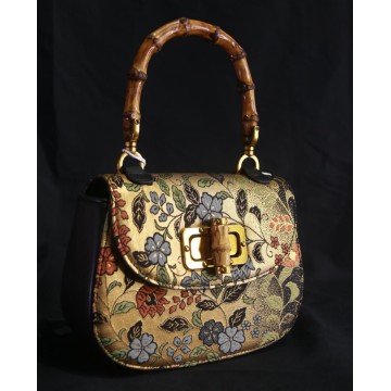 Clutch de seda dorada con mango de bambú