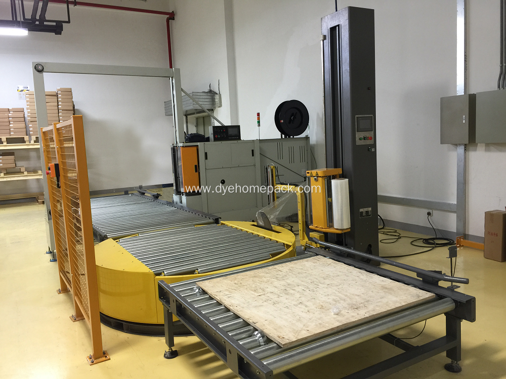 Unmanned pallet wrapping machine with powered conveyor