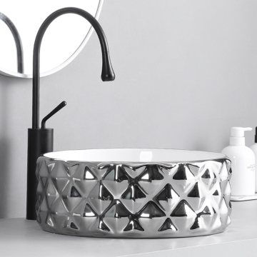 Moderne handgefertigte silbergoldene Lavabo sinken über der Theke des Keramik -Badezimmers