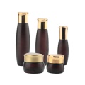Bruine cosmetische glazen fles met gouden doppen