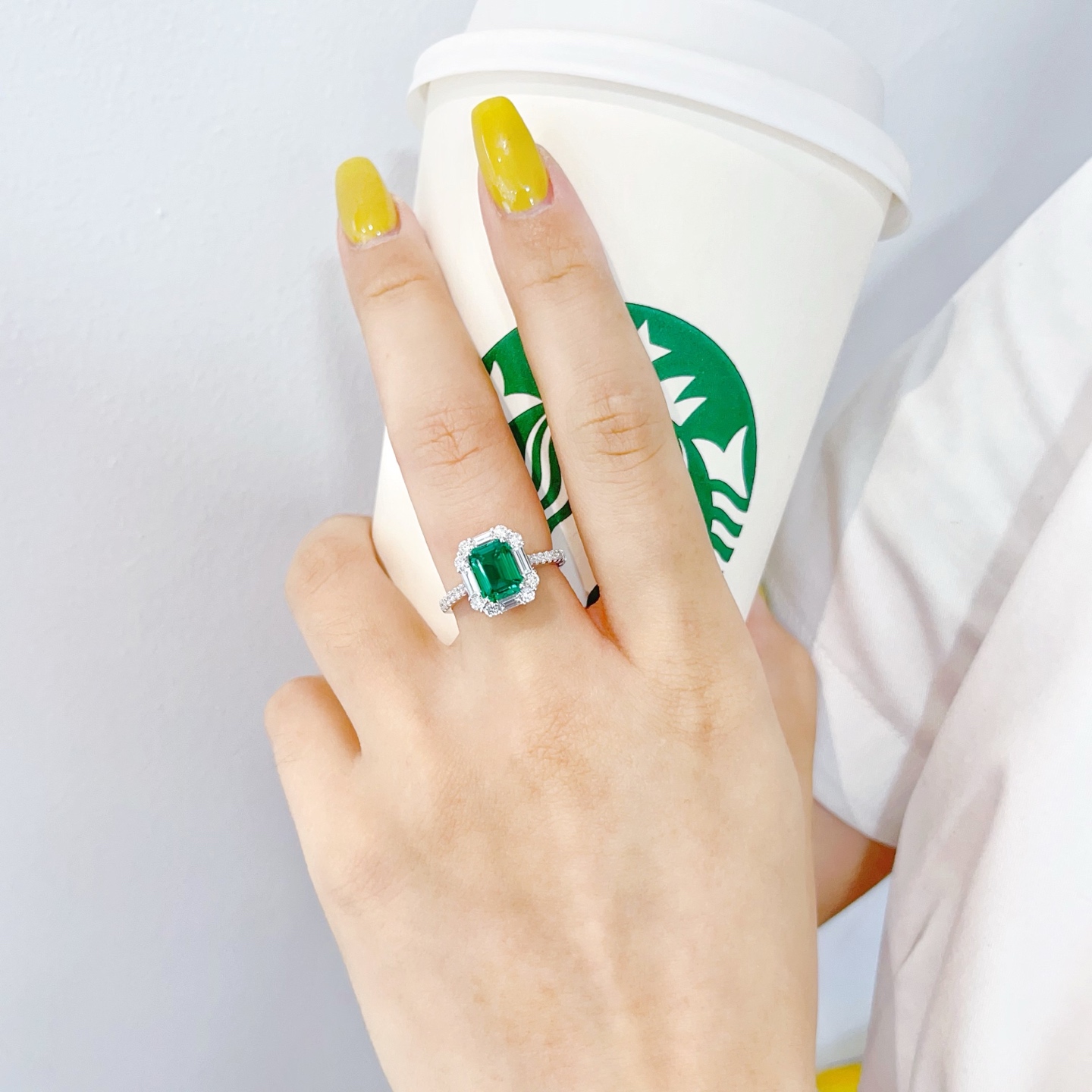 손에 착용하는 18K 화이트 골드 랩그로운 에메랄드 헤일로 약혼 반지