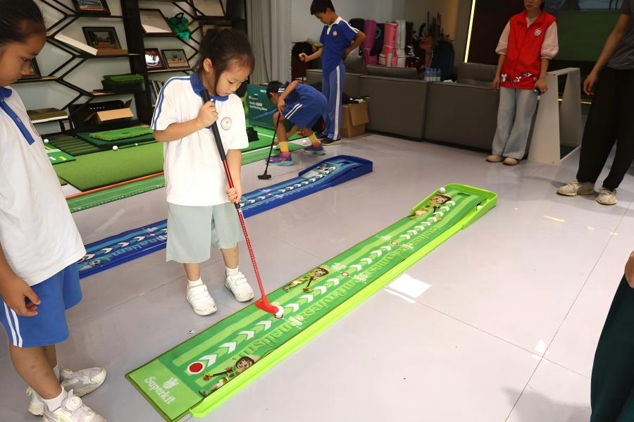 Children learning basic golf putting techniques during a factory community activity