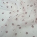 Tessuto in tulle di poliestere con fiori rosa in schiuma e pois dorati