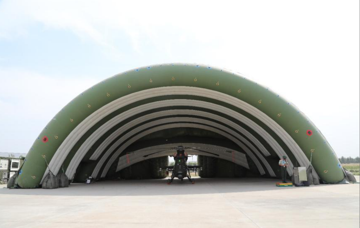 Inflatable hangar sheltering a military helicopter