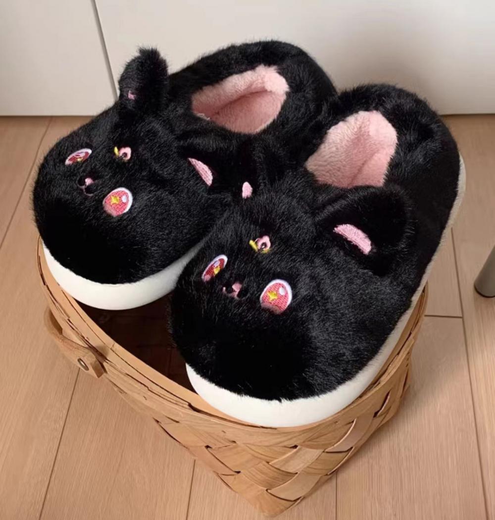 Piccole pantofole di peluche di gatto nero