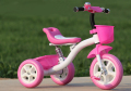 Маленькая девочка с тремя колесами велосипеда