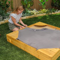 Sandbox de madeira no quintal com móveis de capa para crianças