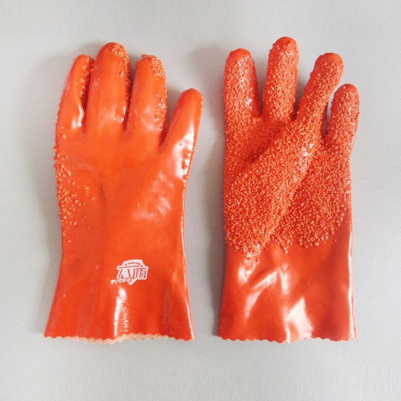 Orange PVC-Handschuhe mit Chips auf der Handfläche