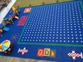 Patio de juegos para niños con azulejos entrelazados Mudolar