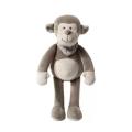 Um macaco cinza simulado acalma um brinquedo de pelúcia