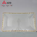 Placa de forma rectangular transparente con vajilla de borde dorado