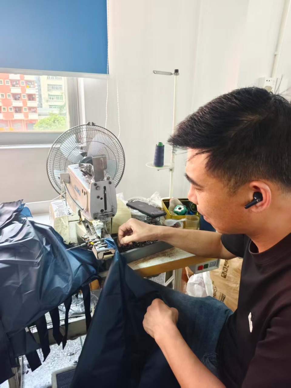 Worker-stitching-umbrella-end-tip-ferrule-on-tips-machine