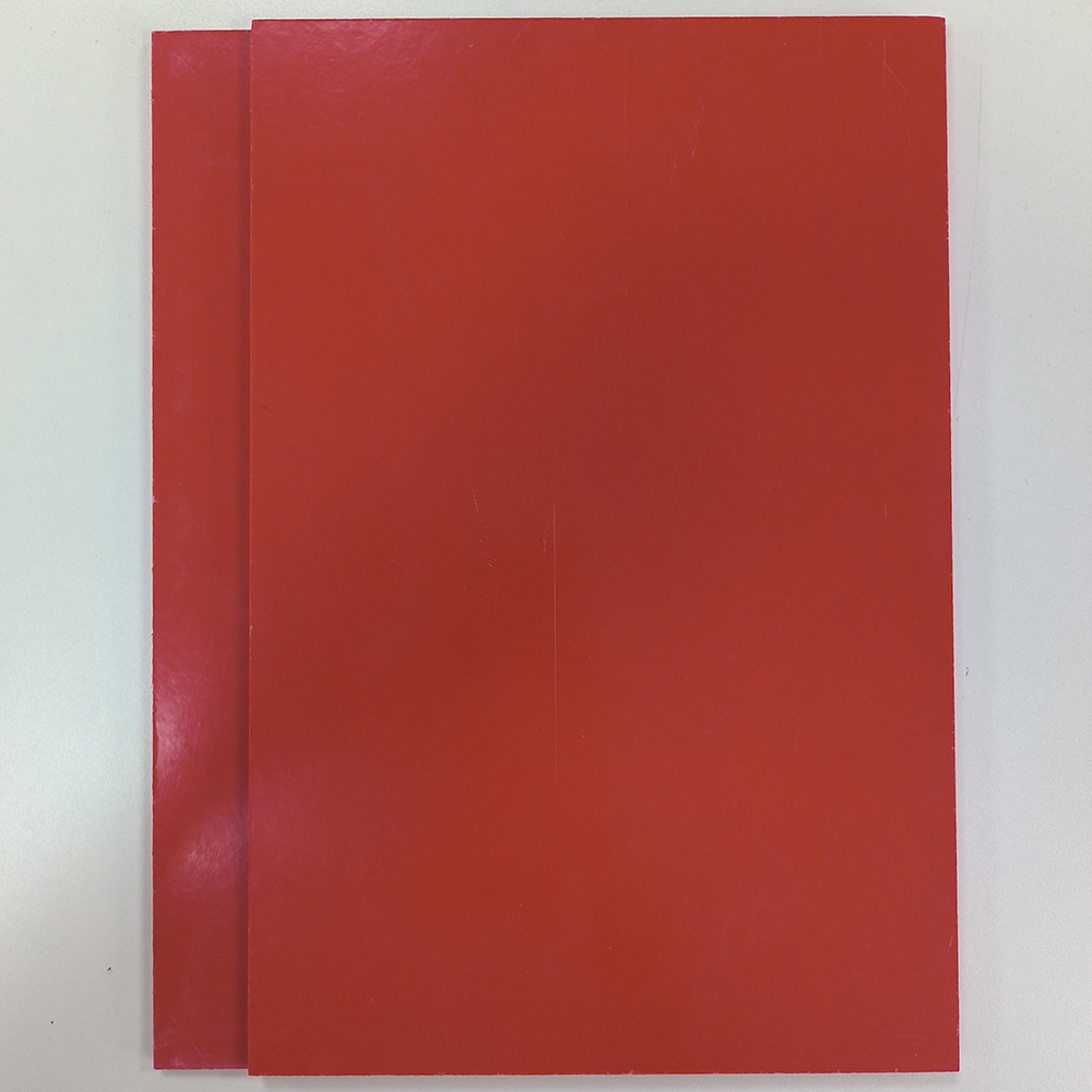Stacked red GPO-3 electrical insulation sheets with smooth, glossy surface