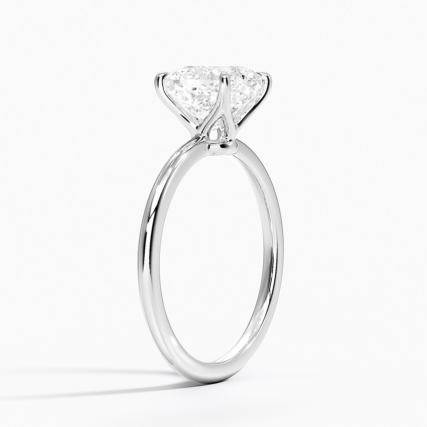 View ng profile na nagpapakita ng maselang 4-prong open gallery na setting ng isang cushion cut diamond ring