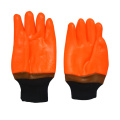 Fluoreszierende orange PVC-beschichtete Handschuhe sandig